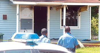 Police officers stand guard at house fire