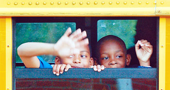 Students wave from school bus