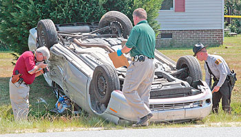 Overturned vehicle with police investigators